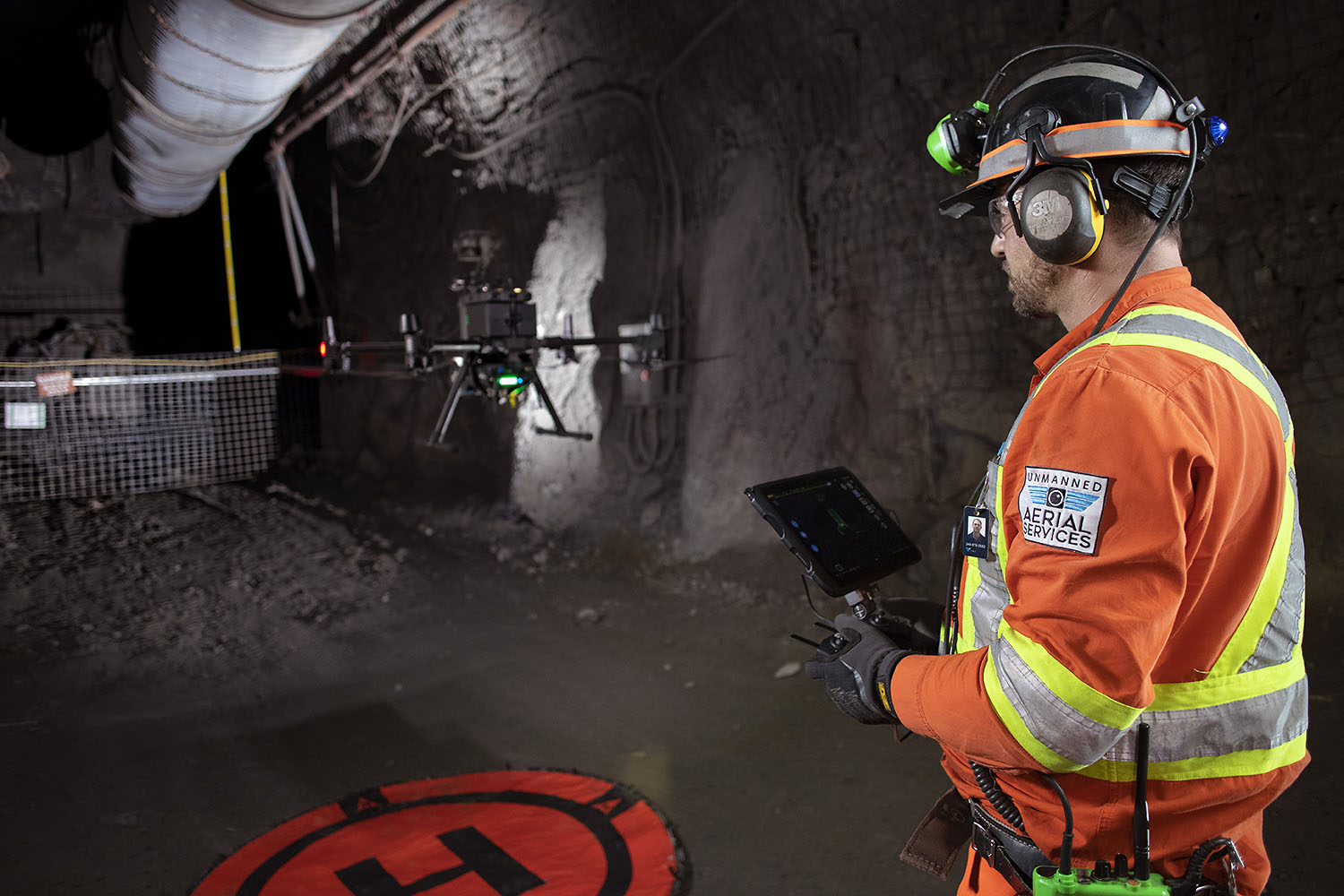 Pilot in profile flying a drone near ventilation ducting underground