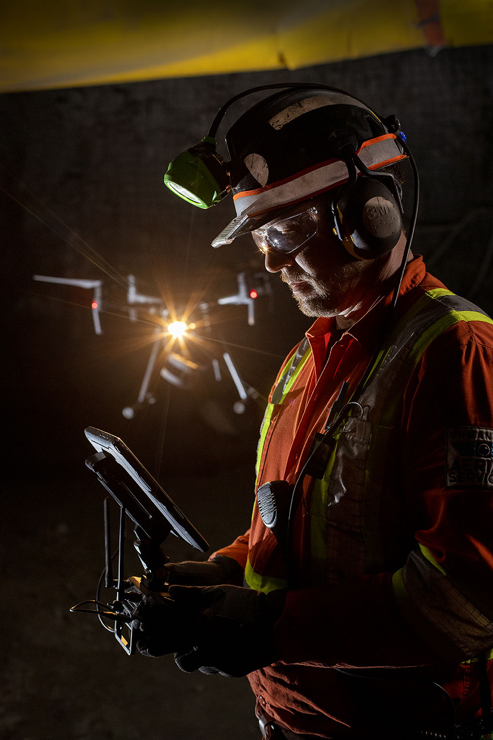 Silhouetted pilot with a drone light flare deep in a mine drift