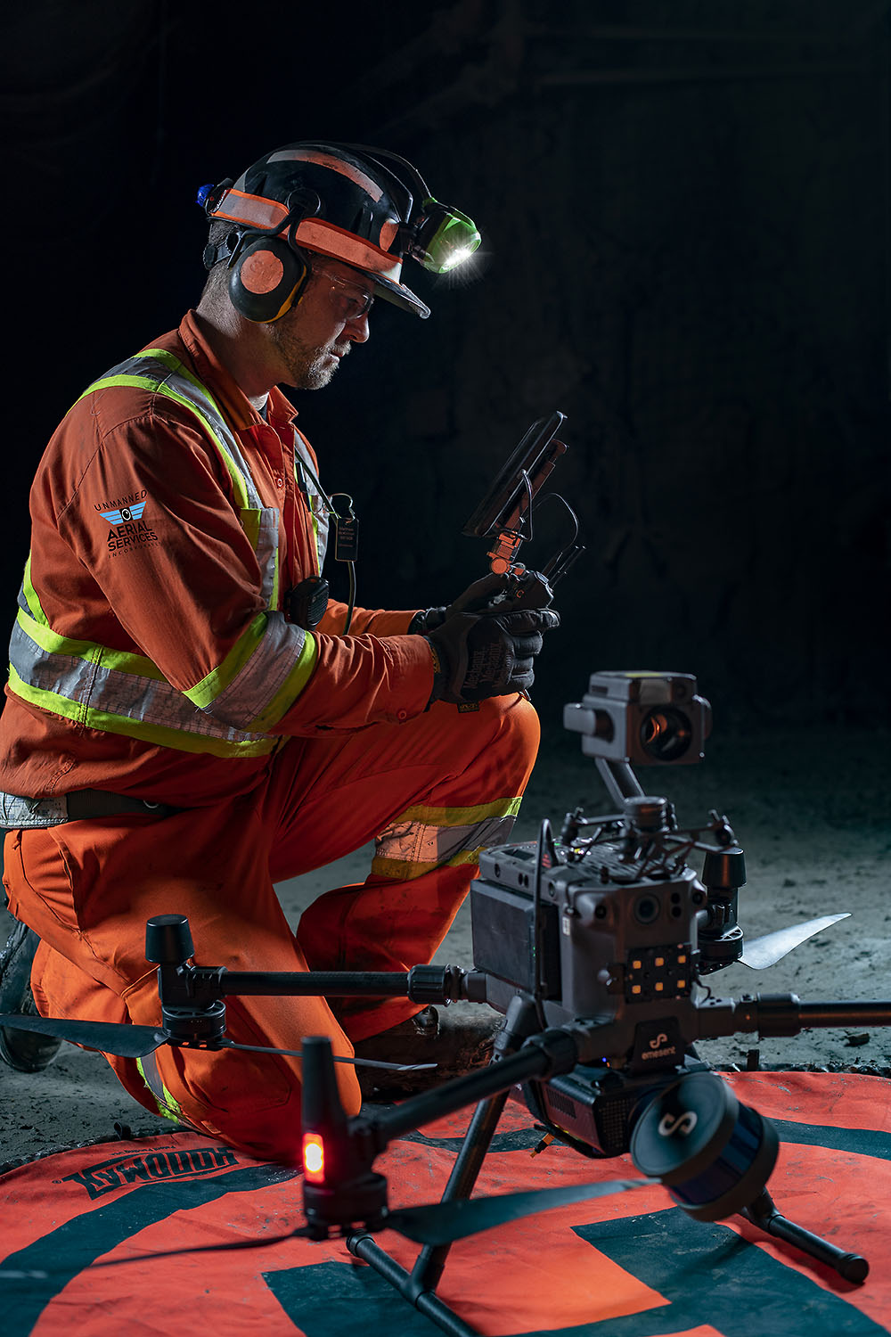 Technician adjusting a drone's thermal camera before a flight
